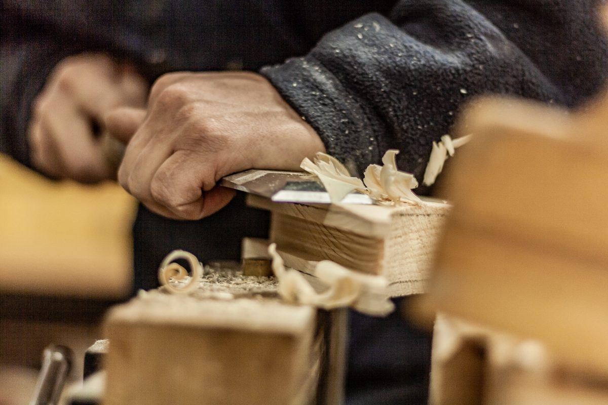 Eco friendly woodworker's shop. Details and focus on the texture of the material, saw dust, and planers or chisels, while making legs for a designer coffee table. Mastering wood with peacefullness.